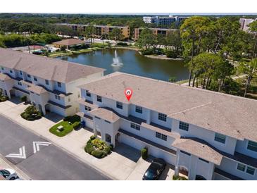 Beautiful aerial view highlighting townhome complex with lake, fountain, and manicured grounds at 8181 Eagles Park N Dr, St Petersburg, FL 33709