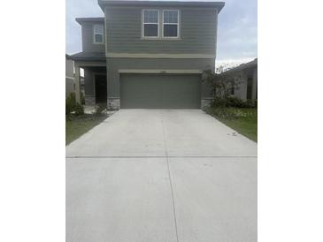 Two-story home featuring a large driveway and a two-car garage at 10448 Ladybug Cv, Parrish, FL 34219
