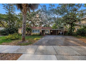 Charming single-story home features a large driveway, carport, mature landscaping and mature shade trees at 1753 San Mateo Dr, Dunedin, FL 34698