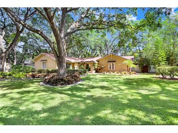 Charming single-story home with mature trees, lush landscaping, and a well-maintained lawn at 2503 Victarra Cir, Lutz, FL 33559