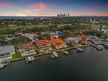 Waterfront home featuring a private dock and pool, offering stunning city views at sunset at 301 Bayview Ne Dr, St Petersburg, FL 33704
