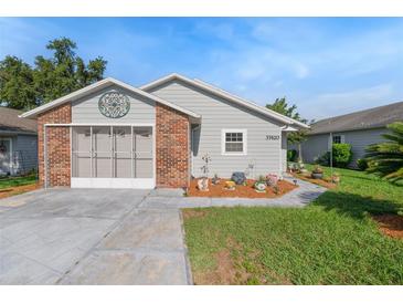 Charming single story home with brick accent, screened garage, colorful landscaping, and well maintained lawn at 37420 Teaberry Loop, Zephyrhills, FL 33542