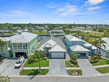 An aerial view shows waterfront homes with lush landscaping, paver driveways and the canal system in the neighborhood at 574 Bimini Bay Blvd, Apollo Beach, FL 33572