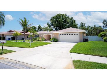 Charming single-story home with well-manicured lawn, mature landscaping, and a two-car garage at 8060 Canterbury Cir, Seminole, FL 33777
