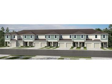 Exterior view of townhomes featuring a two-car garage, modern trim, and manicured lawns at 13248 Stable Pl, Parrish, FL 34219