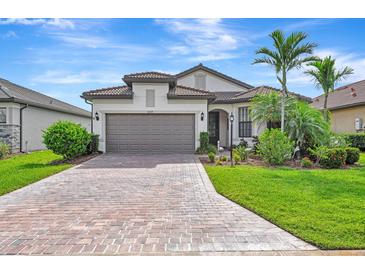 Beautiful home featuring a paved driveway, a two-car garage, and lush landscaping at 16723 Blackwater Ter, Bradenton, FL 34202
