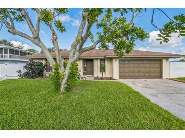 Charming home featuring a well-manicured lawn, mature trees, and a two-car garage at 2204 78Th W St, Bradenton, FL 34209