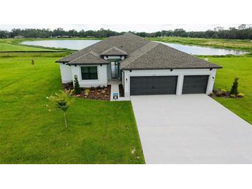 Charming single-story home with a three-car garage, and a well-manicured lawn with lake view at 2414 Hiers Rd, Dover, FL 33527