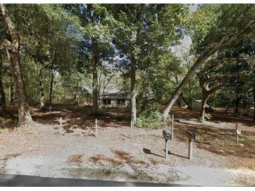 A home exterior behind a sparse fence shaded by mature trees at 25425 Olympia Rd, Brooksville, FL 34601