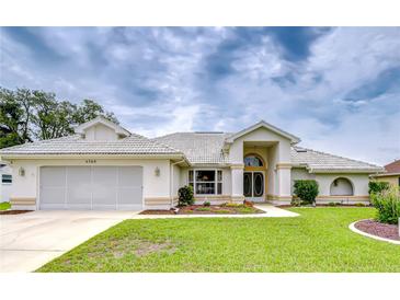 Charming single-story home featuring a well-manicured lawn, arched entryway, and a two-car garage at 4368 Las Palmas Ave, Spring Hill, FL 34606