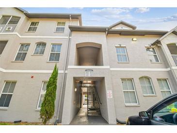 A three-story condo building showing front entrance with covered access and stairs to upper floors at 5052 Sunridge Palms Dr # 102, Tampa, FL 33617