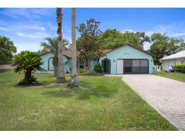 Charming single-story home with a well-manicured lawn and a brick-paved driveway at 8332 Berkeley Manor Blvd, Spring Hill, FL 34606