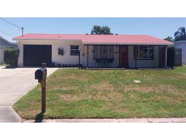 Charming home featuring a well-maintained front yard and a distinctive red metal roof at 10142 118Th Ave, Largo, FL 33773
