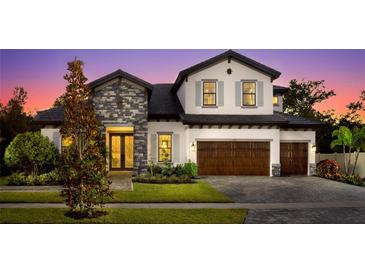 Beautiful two-story home featuring mixed stone and stucco, a three-car garage, and landscaped front yard at 125 Hidden Estates Ct, Brandon, FL 33511