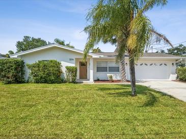 Charming single story home featuring a well-manicured lawn and lush landscaping at 2016 Cove Dr, Largo, FL 33774