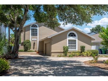 Charming two-story home featuring an attached garage, well-maintained landscaping, and arched windows at 2120 S Hesperides St, Tampa, FL 33629