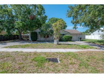 Cozy single-story home featuring mature trees, a large front yard, and a convenient circular driveway at 3256 Adrian Ave, Largo, FL 33774