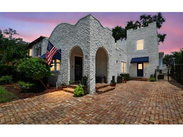 Charming two-story home with unique stucco exterior and brick driveway at 3405 W Palmira Ave, Tampa, FL 33629