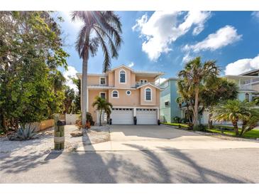 Two-story, single Gathering home with a well-manicured lawn, 2-car garage, and tropical landscaping at 405 8Th N Ave, Tierra Verde, FL 33715
