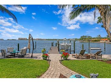 Waterfront backyard featuring a private boat dock, inviting lounge area, and lush landscaping at 4649 Neptune Se Dr, St Petersburg, FL 33705