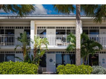 Charming two-story condo building with white trim, balconies, tropical foliage and a serene, inviting atmosphere at 611 Destiny Dr # 204, Ruskin, FL 33570