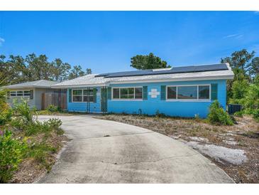 Bright blue single-story home with green shutters and solar panels on a sunny day at 6132 7Th S Ave, Gulfport, FL 33707