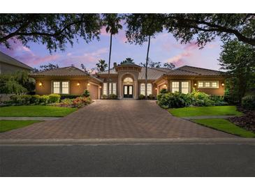 Stunning single-story home featuring a red brick drive, barrel tile roof and lush landscaping at 15110 Kestrelglen Way, Lithia, FL 33547