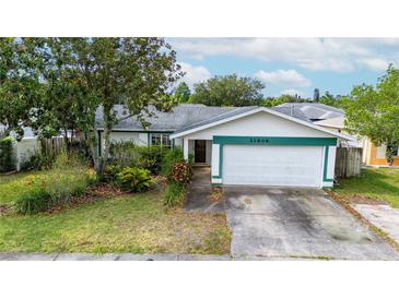 Charming single Gathering home with a two car garage, mature trees, and lush landscaping at 21608 Wytheville Way, Lutz, FL 33549
