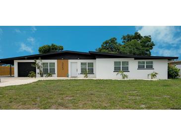 Charming single-story home with a modern black roof, white facade, and minimalist landscaping at 323 48Th Nw St, Bradenton, FL 34209