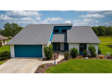 Charming single-Gathering home with well-maintained lawn, attached garage, and vibrant turquoise accents at 34507 Cedarfield Dr, Dade City, FL 33523