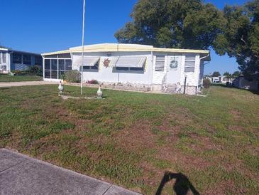 Charming single-story home featuring a decorative lawn, a small porch, and ample natural light at 51 Lexington Ct # 13, Palm Harbor, FL 34684