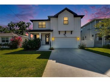 Charming two-story home featuring a well-manicured lawn and a two-car garage at 7203 1/2 S West Shore Blvd, Tampa, FL 33616