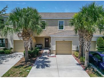 Charming townhome with a one car garage and beautiful palm tree landscaping at 9720 Hound Chase Dr, Gibsonton, FL 33534