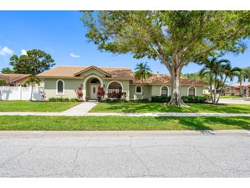 Charming single-story home with a well-maintained lawn and a large shade tree in the front yard at 12470 93Rd St, Largo, FL 33773