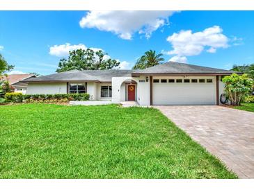 Charming single-story home with a lush green lawn and a brick driveway leading to a two-car garage at 15108 Springview St, Tampa, FL 33624