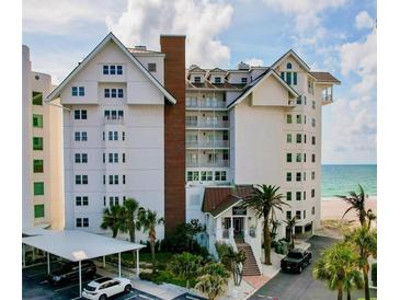 Beautiful exterior view of beachside condo building with well-maintained landscaping, covered parking and ocean view at 1586 Gulf Blvd # 2502, Clearwater, FL 33767