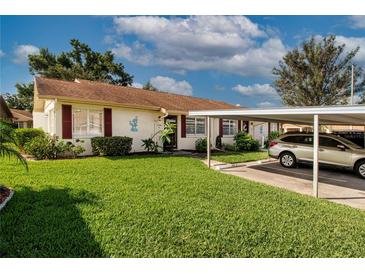 Charming single-story home with well-maintained lawn, covered parking and red shutters at 1828 Foxhunt Dr # A, Sun City Center, FL 33573