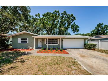 Charming home featuring a well-maintained front yard and a convenient attached garage at 1926 Fairway W Cir, Dunedin, FL 34698