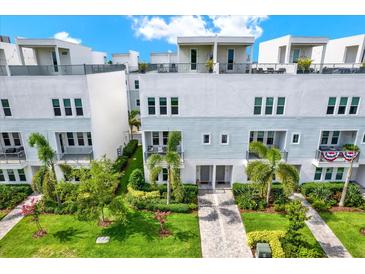 Beautiful modern townhomes feature lush landscaping, private balconies, and a charming brick pathway at 2442 W Mississippi Ave # 5, Tampa, FL 33629