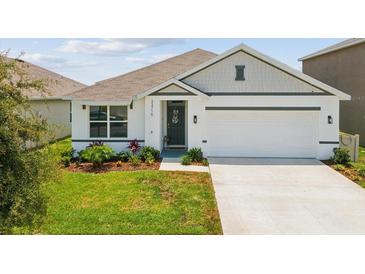Charming single-story home with a well-manicured lawn and a two-car garage at 33716 Elm Hill Br, Wesley Chapel, FL 33545