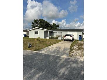 Charming single-story home featuring a well-maintained lawn and a paved driveway leading to an attached garage at 3612 Devonshire Dr, Holiday, FL 34691