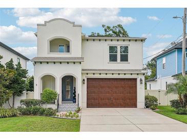 Charming two-story stucco home featuring a two-car garage and beautifully landscaped front yard at 4115 N Blvd, Tampa, FL 33603
