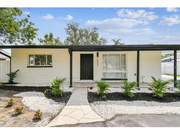 Charming single-story home with white exterior, black trim, and rock landscaping at 4461 Shore Acres Ne Blvd, St Petersburg, FL 33703