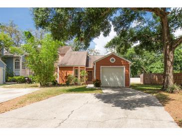 Charming single-Gathering home with a well-maintained lawn and a one-car garage on a sunny day at 9466 Forest Hills Cir, Tampa, FL 33612