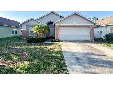 Charming single-story home featuring a two-car garage, brick accents, and a well-maintained front yard at 9735 Riverchase Dr, New Port Richey, FL 34655