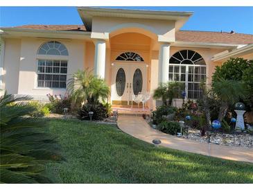 Charming home entrance with double doors, columns, arched entry and lush landscaping at 13339 Amberwood St, Hudson, FL 34669