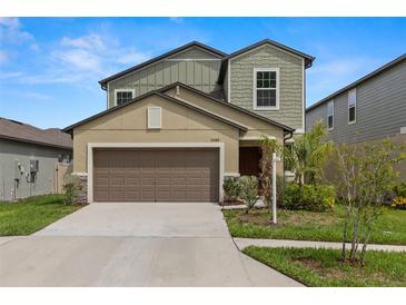 Two story home featuring a two car garage, neutral paint colors, and landscaped yard at 22489 Storybook Cabin Way, Land O Lakes, FL 34637
