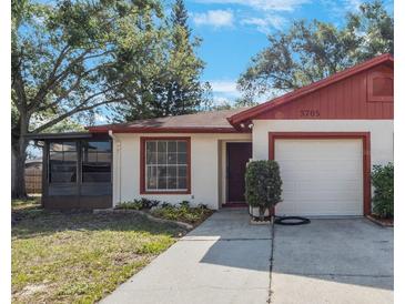 Charming single-story home with a manicured lawn and a screened-in porch, perfect for enjoying the outdoors at 3705 Simpson Ct, Palm Harbor, FL 34684