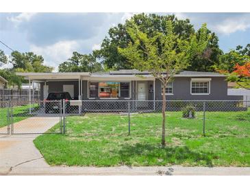 Charming single-story home featuring a fenced front yard, covered parking and beautiful landscaping at 4512 S Lois Ave, Tampa, FL 33611