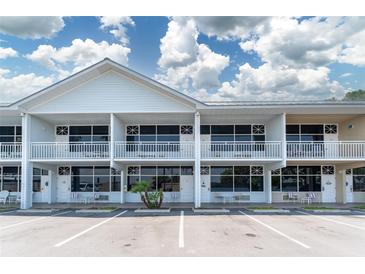 Bright exterior view of the waterfront condo building with balconies, parking, and manicured landscaping at 611 Destiny Dr # 509, Ruskin, FL 33570